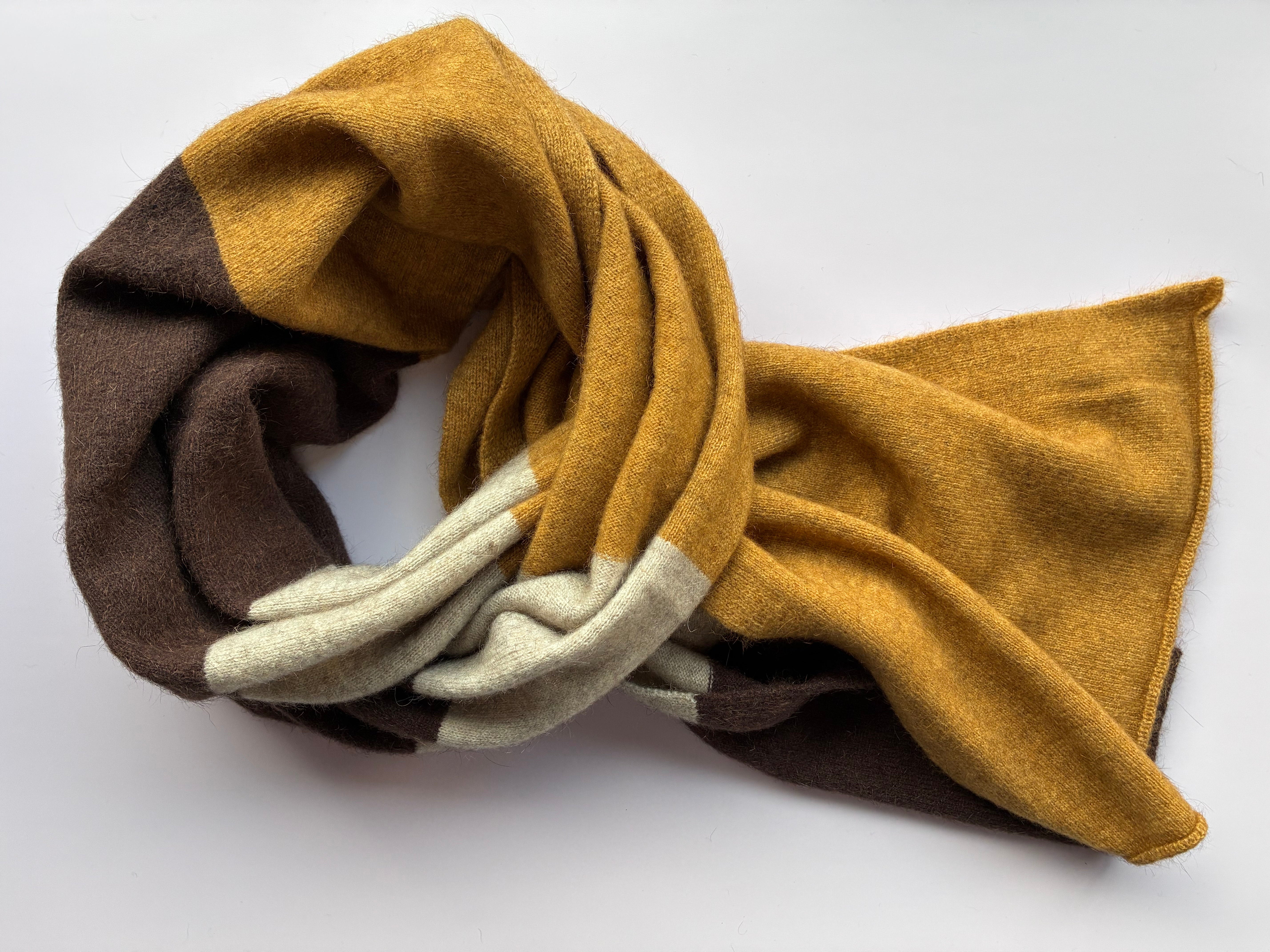 Multicolored scarf with brown, beige, and white hues on a white background