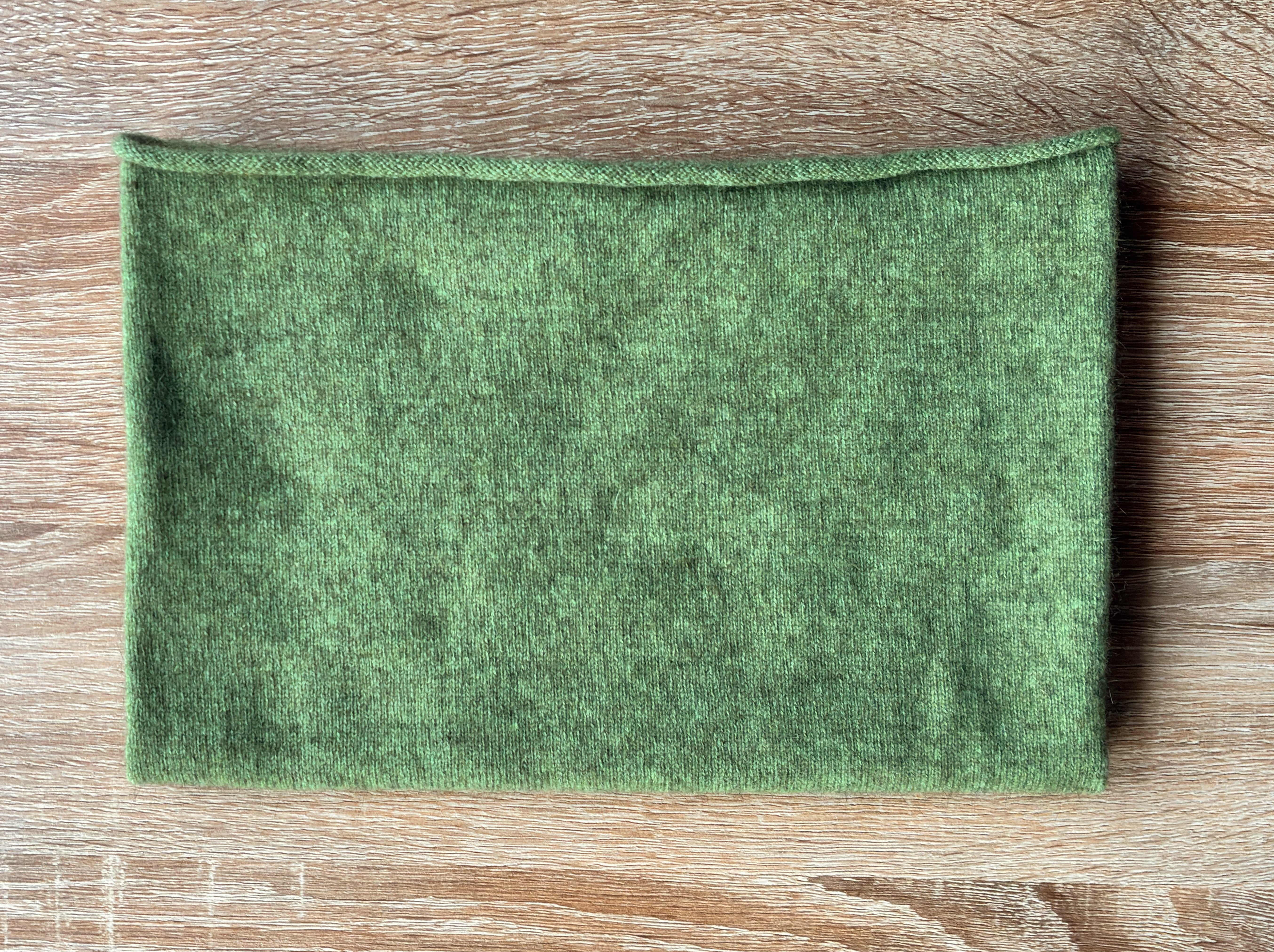 Pistachio green possum merino Neckwarmer on a table