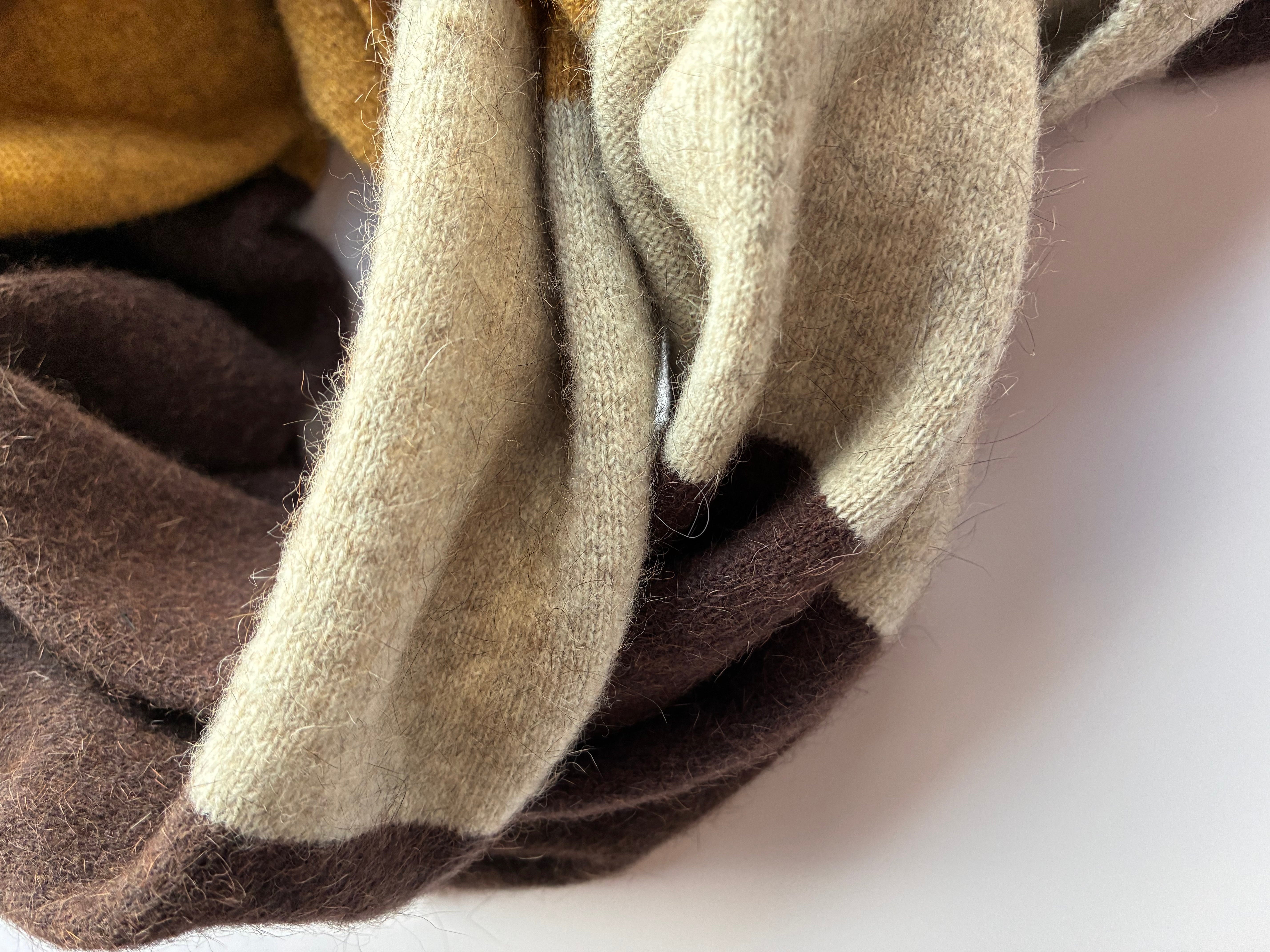 Close-up of textured fabric in brown, beige, and gray on a white background