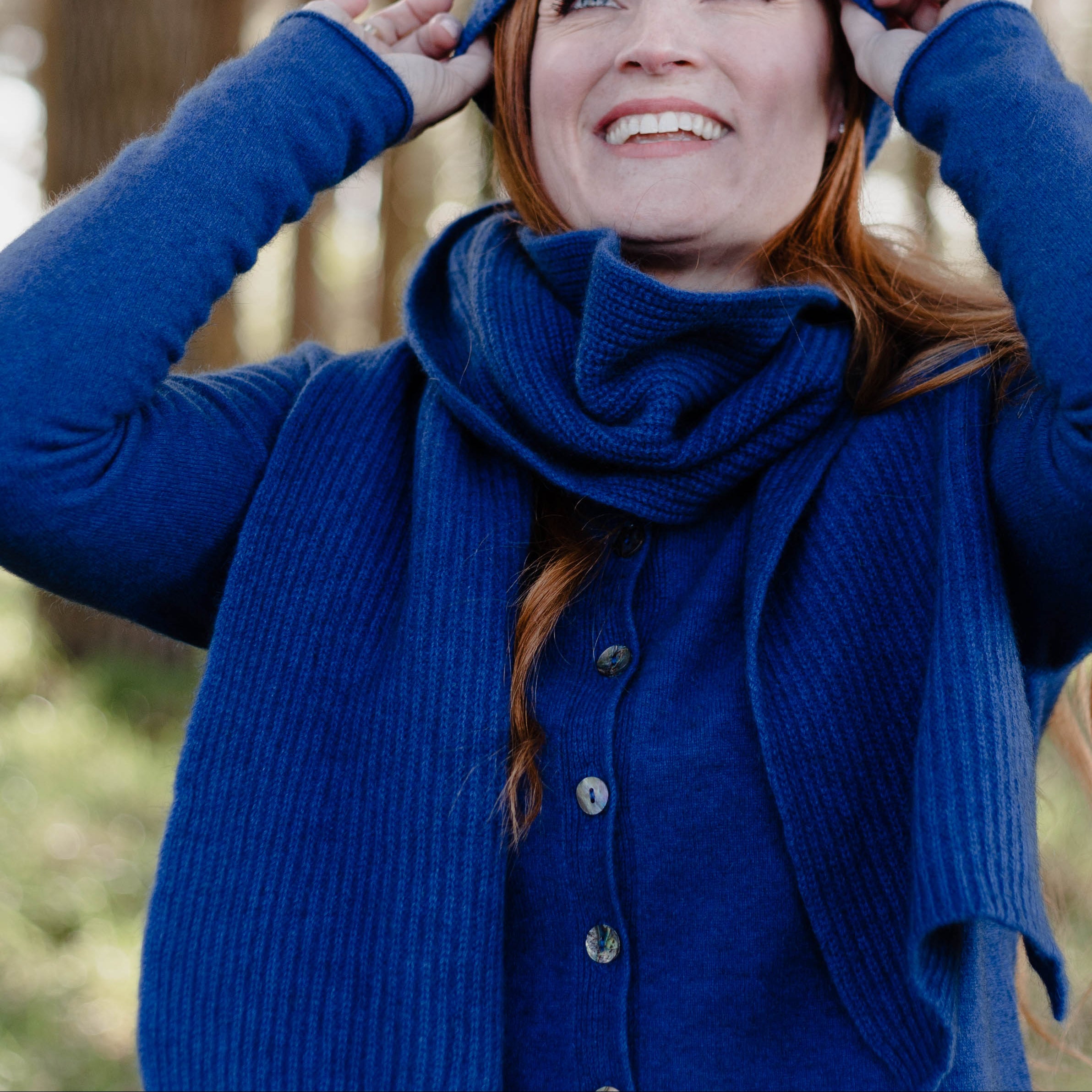 Woman in a blue outfit standing in a forest