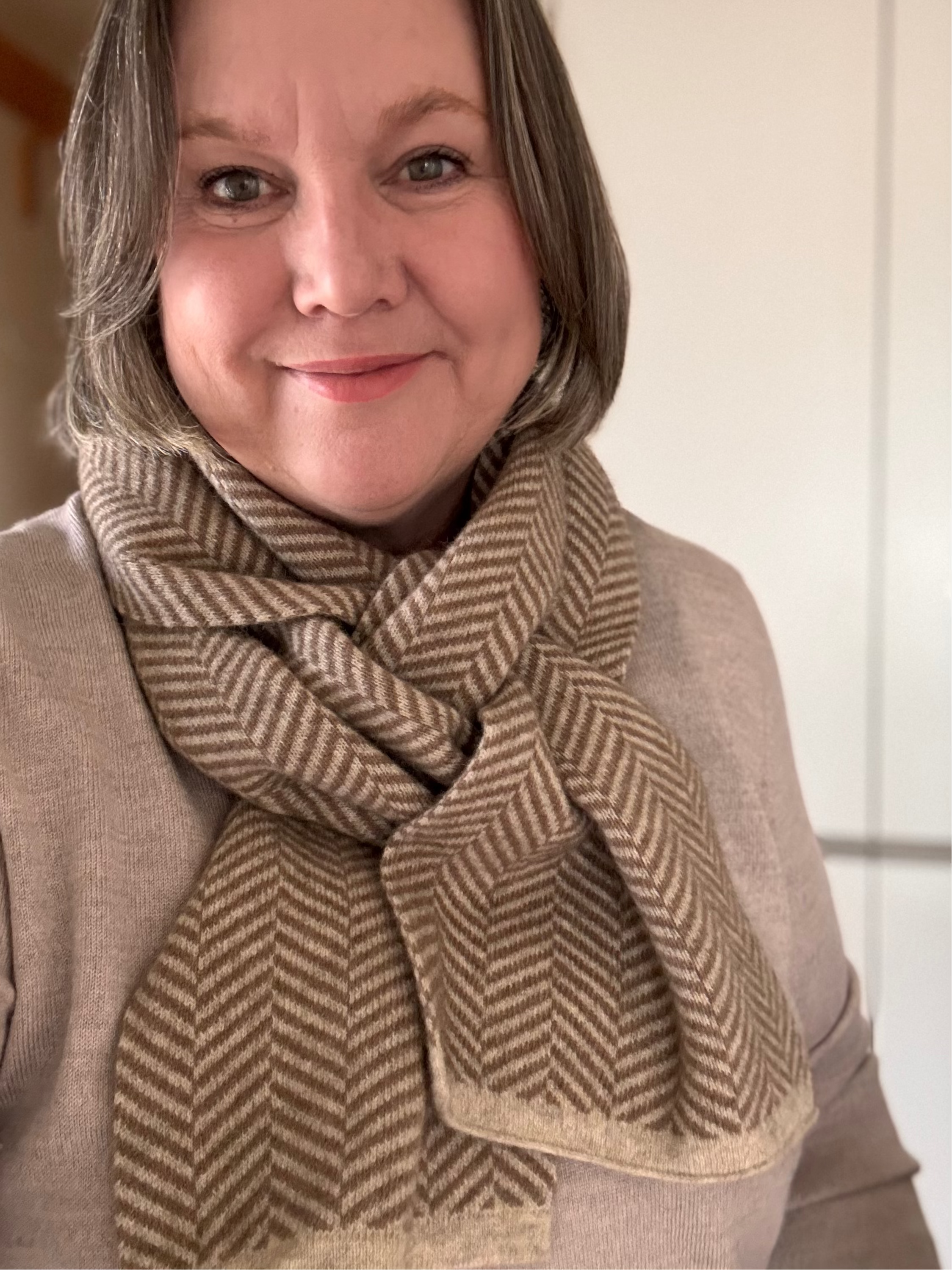 Woman wearing a brown herringbone patterned scarf